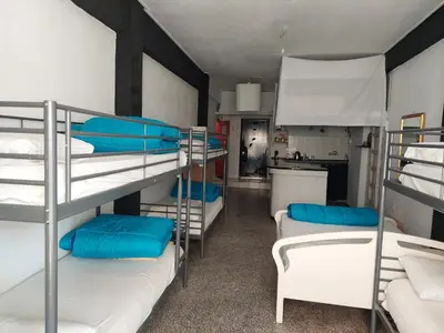 a room with three bunk beds and a kitchen at ACROPOLI AND MONASTIRAKI HOMe1 in Athens