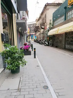 an empty city street with buildings and plants at ACROPOLI AND MONASTIRAKI HOMe1 in Athens