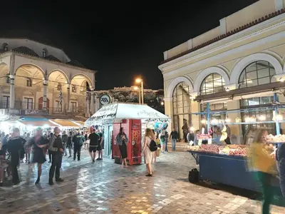 a group of people walking around a market at night at ACROPOLI AND MONASTIRAKI HOMe1 in Athens