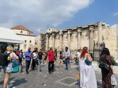 a group of people walking in front of a building at ACROPOLI AND MONASTIRAKI HOMe1 in Athens