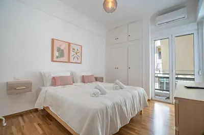 a white bedroom with a large white bed with pink pillows at Casa di Anna 1 bed 4 pers Apt by MPS in Athens