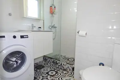a bathroom with a washing machine and a toilet at Casa di Anna 1 bed 4 pers Apt by MPS in Athens