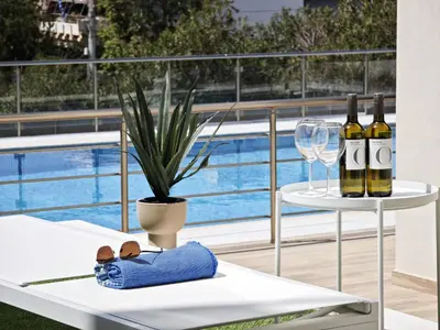 a table with two bottles of wine and a glass at Costa Voula Poolside and Beach, Home Cinema in Athens