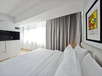 a bedroom with a white bed and a large window at Costa Voula Poolside and Beach, Home Cinema in Athens
