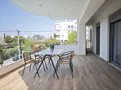 a table and chairs on a balcony with a view at Costa Voula Poolside and Beach, Home Cinema in Athens