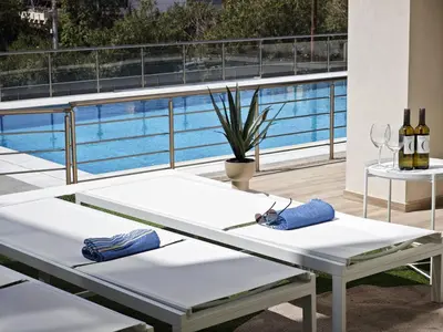 a white table on a balcony with a pool at Costa Voula Poolside and Beach, Home Cinema in Athens