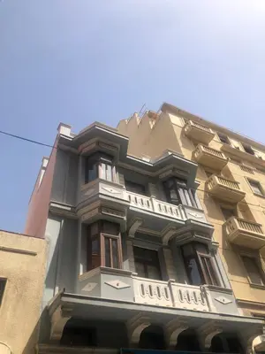 a tall building with a balcony on the side of it at Heritage house in Athens' heart in Athens