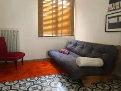 a living room with a blue couch and a red chair at Heritage house in Athens' heart in Athens