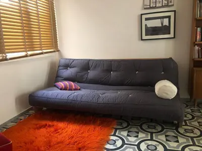 a blue couch in a living room with an orange rug at Heritage house in Athens' heart in Athens