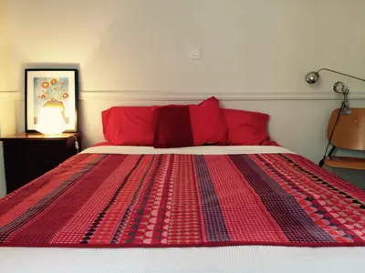 a bed with red pillows and a red blanket at Heritage house in Athens' heart in Athens