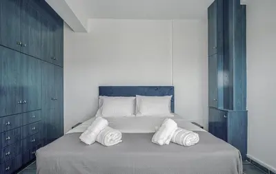 a bedroom with a bed with three pillows on it at Sea View Residence Panorama Villa in Saronida