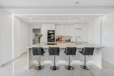 a kitchen with a island with four black bar stools at Sea View Residence Panorama Villa in Saronida