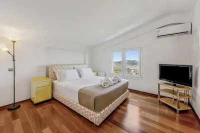 a bedroom with a bed and a flat screen tv at Sea View Residence Panorama Villa in Saronida