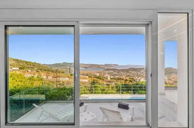 an open glass door with a view of a balcony at Sea View Residence Panorama Villa in Saronida