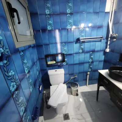 a blue tiled bathroom with a toilet and a sink at Athens King 1 in Athens