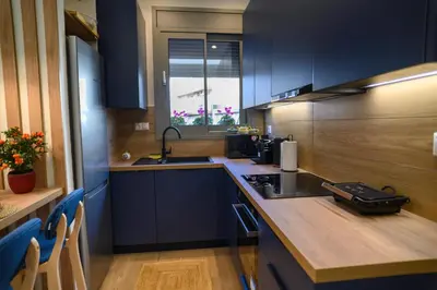 a kitchen with blue cabinets and a counter top at Daisy's Deluxe Athenian 2bedroom by MPS in Athens