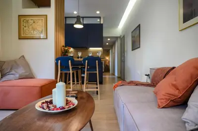 a living room with a couch and a table with a candle at Daisy's Deluxe Athenian 2bedroom by MPS in Athens
