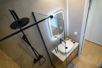 a bathroom with a sink and a mirror at Daisy's Deluxe Athenian 2bedroom by MPS in Athens