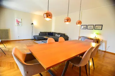 a living room with a wooden table and chairs at Athens stylish apt 2 min walk to the beach , tram in Athens