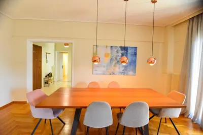 a dining room with a wooden table and chairs at Athens stylish apt 2 min walk to the beach , tram in Athens