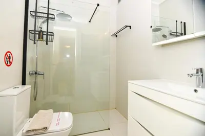 a bathroom with a shower and a toilet and a sink at Athens stylish apt 2 min walk to the beach , tram in Athens