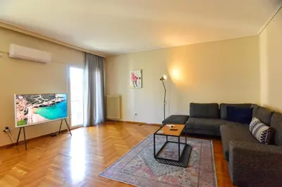 a living room with a couch and a flat screen tv at Athens stylish apt 2 min walk to the beach , tram in Athens