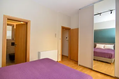 a bedroom with a purple bed and a mirror at Athens centre top floor stylish 2 min walk metro in Athens