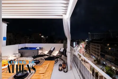a balcony with chairs and a view of a city at Eugene's Loft - Acropolis View - Jacuzzi 2&1 ppl in Athens