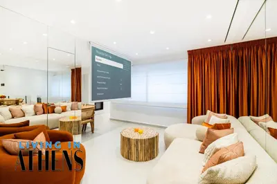 a living room with couches and a large screen at Eugene's Luxury Apt 2&1 ppl 3min Walking Distance to Metro Station in Athens