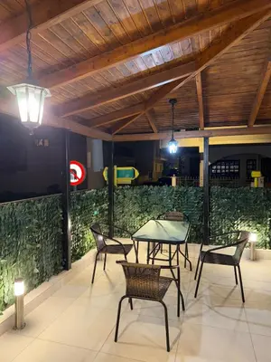 a patio with a table and chairs and a green wall at Urban Luxy Staycation in Athens