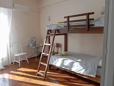 a bedroom with two bunk beds and a desk at 4 Single beds room 5' from metro in Athens