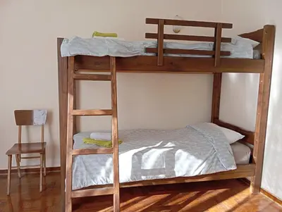 two bunk beds in a room with a chair at 4 Single beds room 5' from metro in Athens
