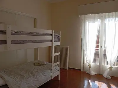 a bedroom with two bunk beds and a window at 4 Single beds room 5' from metro in Athens