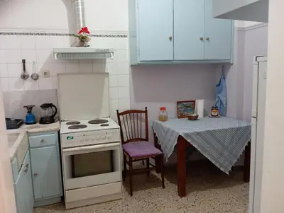 a small kitchen with a table and a stove at 4 Single beds room 5' from metro in Athens