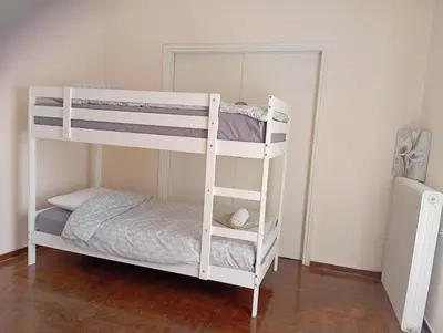 a white bunk bed in a room with a mirror at 4 Single beds room 5' from metro in Athens