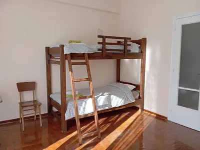 a bunk bed with a ladder in a room at 4 Single beds room 5' from metro in Athens