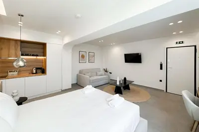 a white bedroom with a large bed and a couch at Megaro Luxury Suite 11 in Syntagma in Athens