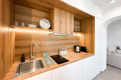 a kitchen with a sink and wooden cabinets at Megaro Luxury Suite 11 in Syntagma in Athens