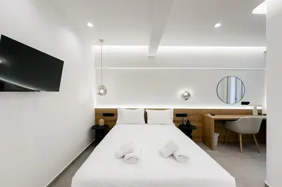 a bedroom with a white bed and a desk at Megaro Luxury Suite 7 in Syntagma in Athens