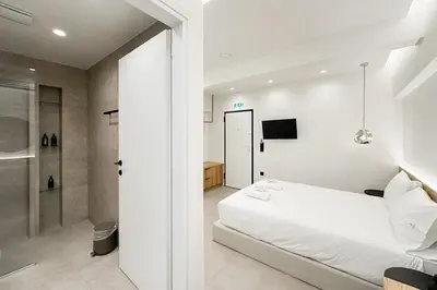 a white bedroom with a bed and a shower at Megaro Luxury Suite 7 in Syntagma in Athens