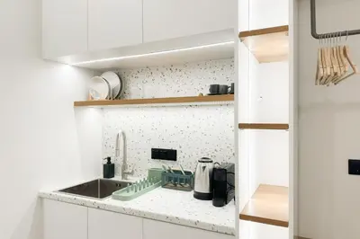 a kitchen with white cabinets and a sink at Megaro Luxury Suite 7 in Syntagma in Athens
