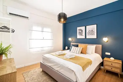 a bedroom with a blue accent wall and a bed at Beautiful Apartment in the most Iconic area in Athens in Athens