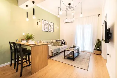 a living room with a couch and a table with chairs at Beautiful Apartment in the most Iconic area in Athens in Athens