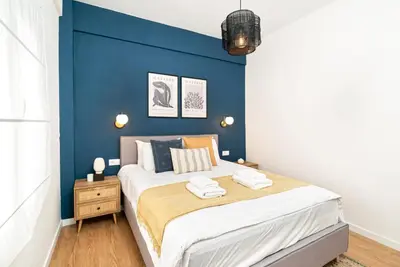 a bedroom with a blue accent wall and a bed at Beautiful Apartment in the most Iconic area in Athens in Athens