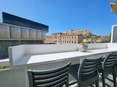 a table and chairs on a balcony with a view at Acropolis Panorama Suite by YHA in Athens