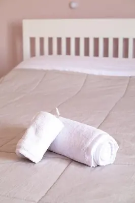 a roll of toilet paper sitting on a bed at Airport city center in Spáta