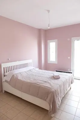 a white bedroom with a large bed in a room at Airport city center in Spáta