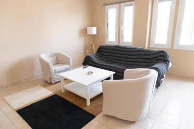 a living room with a couch and a table and chairs at Airport city center in Spáta