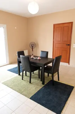 a dining room with a black table and chairs at Airport city center in Spáta