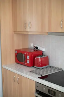 a red toaster sitting on a counter in a kitchen at Airport city center in Spáta